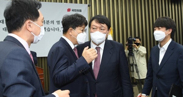 국민의힘 윤석열 대선후보가 8일 국회에서 열린 현인보고에 참석해 후보 비서실장에 선임된 권성동 의원의 귀엣말을 듣고 있다. / 연합뉴스