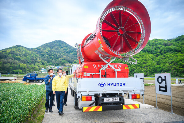 장충남 남해군수가 친환경 광역방제기 미생물 살포 시연에 참석해 살펴보고 있다./남해군청 제공.