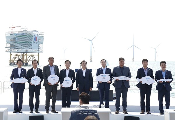 문재인 대통령이 2020년 7월 전북 부안군 해상풍력 실증단지에서 열린 '한국판 뉴딜, 그린 에너지 현장 - 바람이 분다' 행사에서 전북 서남권 해상풍력 MOU 체결식 참여자들과 특산물 모형을 들고 기념촬영 하고 있다. / 청와대 제공