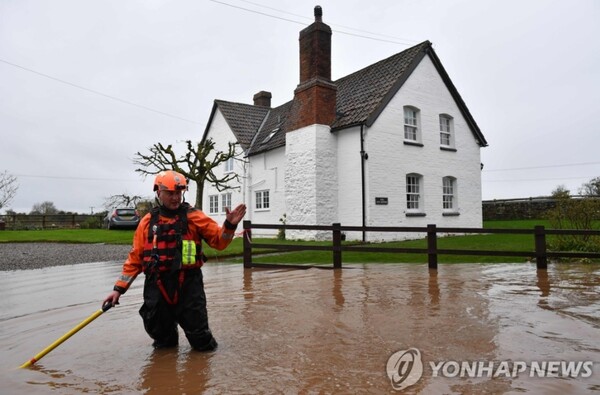 집중호우와 강의 범람으로 영국 한 주택가 도로가 침수된 모습/연합뉴스