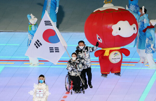 4일 중국 베이징 국립경기장에서 열린 2022 베이징 패럴림픽 개회식에서 한국 선수단의 기수를 맡은 휠체어컬링 대표팀 '장윤정 고백'의 리드 백혜진(앞에서 2번째)이 태극기를 앞세우고 입장하고 있다. /연합뉴스