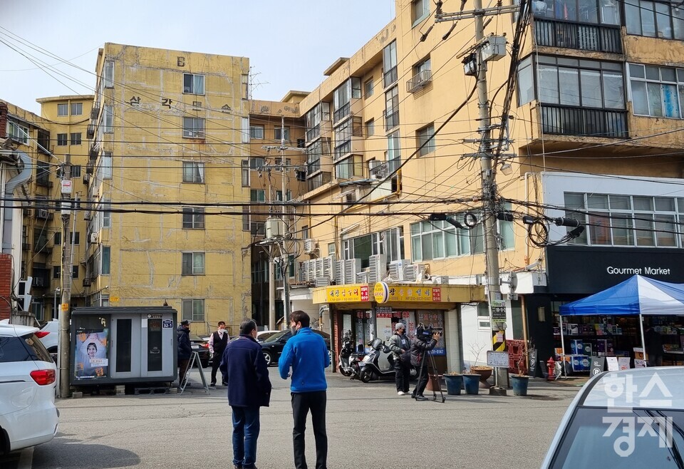 서울 용산 삼각맨션 주변 주민들이 방송 카메라 촬영을 지켜보고 있다. / 서동영 기자