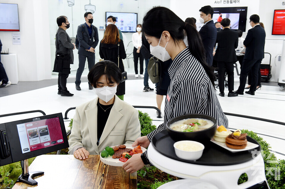 한 시민이 KT 부스를 찾아 서빙 로봇 시스템을 체험하고 있다. /코엑스=김근현 기자