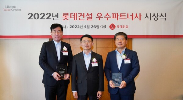 하석주 롯데건설 대표(가운데)와 2022년 우수 파트너사 대상으로 선정된 박준석 아세아종합건설 대표(왼쪽), 송명근 두송건설 대표(오른쪽)가 사진촬영을 하고 있다. / 롯데건설 제공