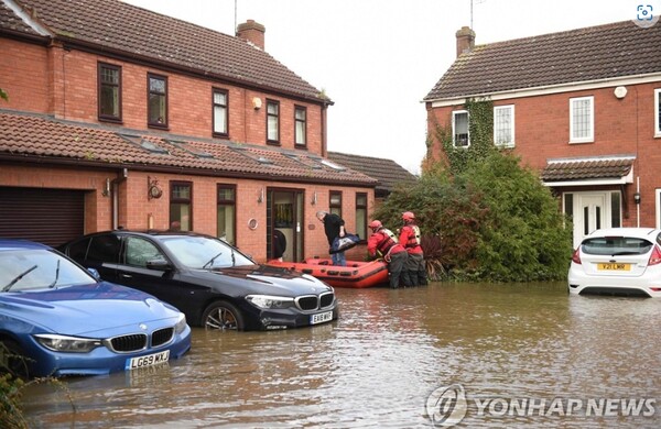 소방구조서비스 대원들이 홍수 피해를 겪은 영국 잉글랜드 지역에서 구조활동을 펴는 모습/연합뉴스