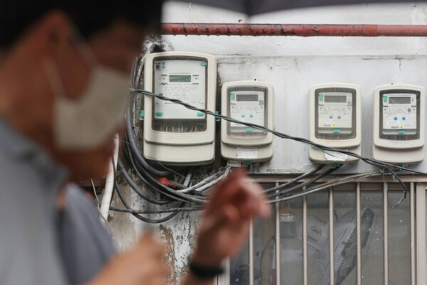 올해 3분기 전기요금의 연료비 조정단가가 발표된 27일 서울 시내의 전기계량기 앞을 시민들이 지나가고 있다. / 연합뉴스