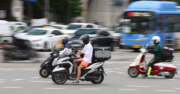 28일 서울 시내에서 한 오토바이 운전자가 휴대전화를 보며 교차로를 지나고 있다. / 연합뉴스
