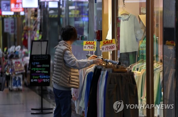 서울 명동 인근 지하상가 한 옷 가게에서 상인이 옷을 진열하고 있다. /연합뉴스