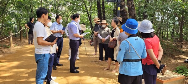 이오수 경기도의원이 지역 주민들과 함께 맨발로 걷는 산책로를 돌아보며 의견을 청취하고 있다./경기도의회 제공