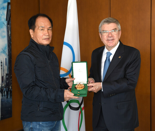 김민제(왼쪽) 사진작가가 토마스 바흐 IOC 위원장으로부터 쿠베르탱 메달을 받고 있다. /한국체육기자연맹 제공