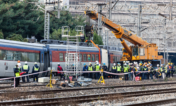 7일 오전 탈선된 열차를 철로에 올리기 위한 작업을 진행 중인 코레인 복구반원. / 연합뉴스 