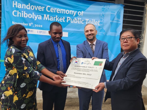 지난 11월8일 잠비아 치볼야마켓 수원화장실 준공식에서 수원화장실이라고 적힌 현판이 전달되고 있다./ 수원시 제공