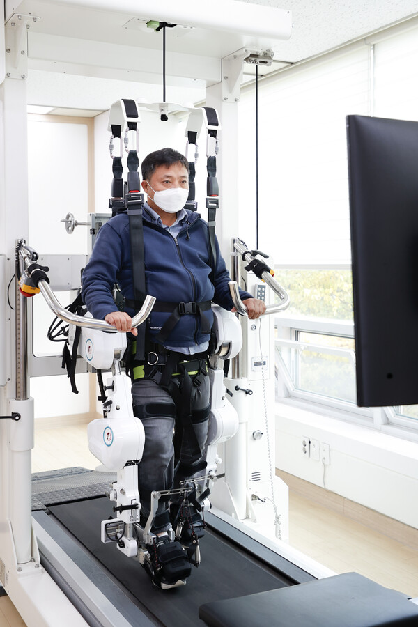 안정경씨가 기흥장애인복지관에 설치된 워크봇G에 올라 재활치료를 받고 있다./ 용인시 제공