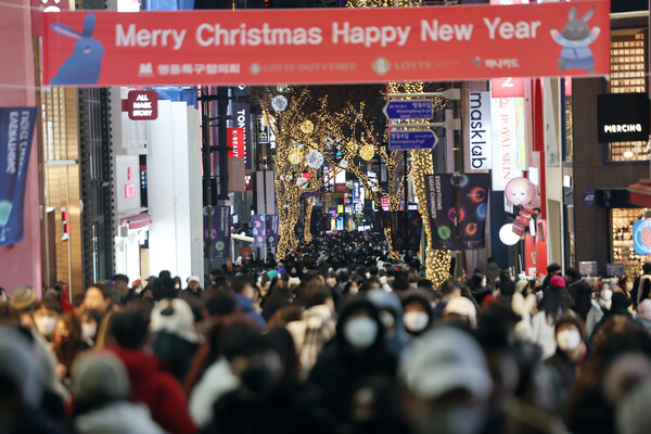 크리스마스 이브인 지난 24일 서울 명동거리에서 시민들이 연말 분위기를 즐기고 있다./연합뉴스.