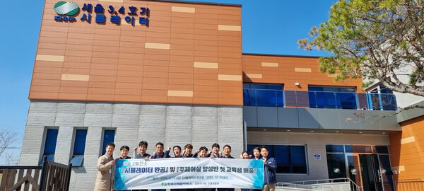 새울 3,4호기 시뮬레이터 건물을 배경 으로 교육생들이 단체사진을 촬영하고 있다. / 한수원 제공 