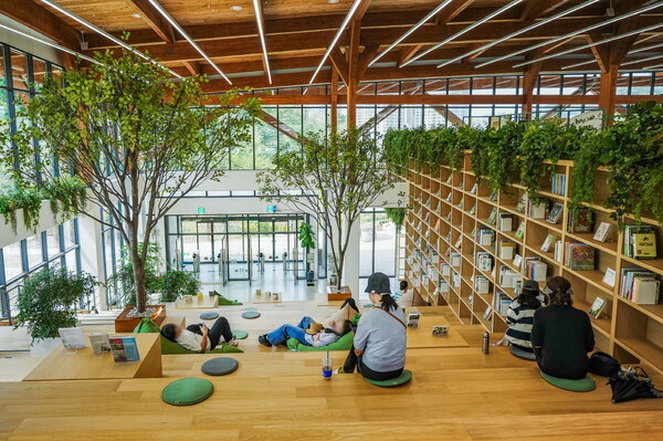 영흥수목원 방문자센터 중 무료로 개방하고 있는 책마루에서 시민들이 책을 읽으며 쉬고 있다./ 수원시 제공