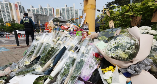 지난 11일 오후 경기도 수원시의 한 사거리에 전날 어린이보호구역에서 시내버스에 치여 숨진 초등학생을 추모하는 시민들이 놓고 간 꽃과 장난감./ 연합뉴스