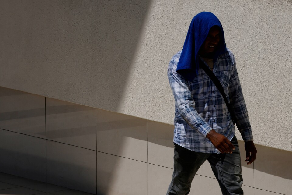 싱가포르에서 폭염이 이어지는 가운데 15일(현지시간) 수도 싱가포르에서 한 이주노동자가 수건으로 얼굴을 덮고 있다. 지난 13일 싱가포르는 최고기온이 37도까지 치솟았다. 이는 40년 전인 1983년에 기록한 역대 최고 기온과 같다. / 연합뉴스