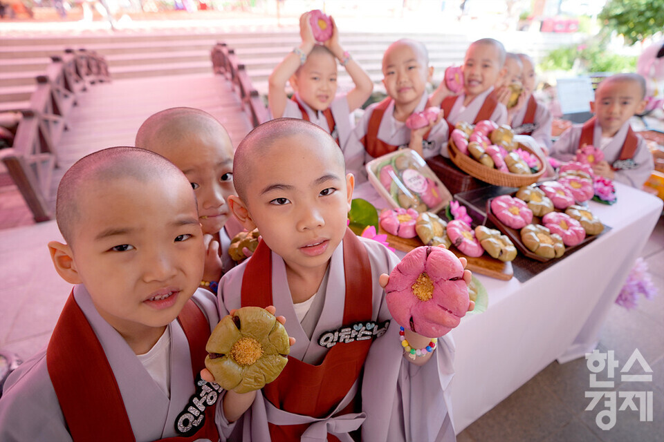 단기출가 과정 '보리수 새싹학교'에 참가한 동자승들이 23일 오전 서울 종로구 조계사에서 '연꽃단팥빵'을 소개하고 있다. 신세계푸드가 부처님오신날을 맞아 출시한 '연꽃단팥빵'은 우유, 계란, 버터 없이 100% 식물성 재료로 만든 단팥빵으로 백년초와 연잎 가루로 색을 내고, 불교의 6개 수행덕목을 상징하는 '육바라밀'의 의미를 6개의 꼬잎 모양에 담은 것이 특징이다. /김근현 기자 khkim@sporbiz.co.kr 2023.05.23.