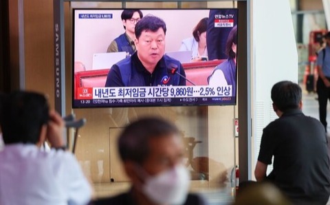 내년도 최저임금이 시급 9860원으로 결정된 가운데 지난 19일 시민들이 서울역 대합실에서 TV로 관련 뉴스를 지켜보고 있다. /연합뉴스