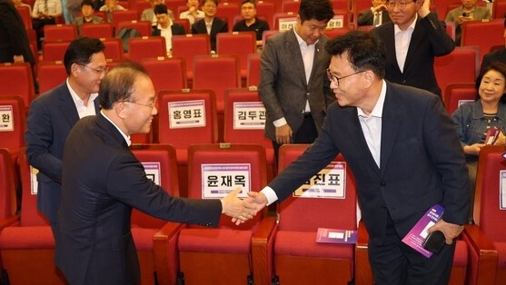 윤재옥 국민의힘 원내대표와 박광온 더불어민주당 원내대표가 지난 18일 국회에서 열린 ‘정치양극화 시대 한국의 민주주의의 발전방안’ 출판기념회에서 악수하고 있다. /연합뉴스