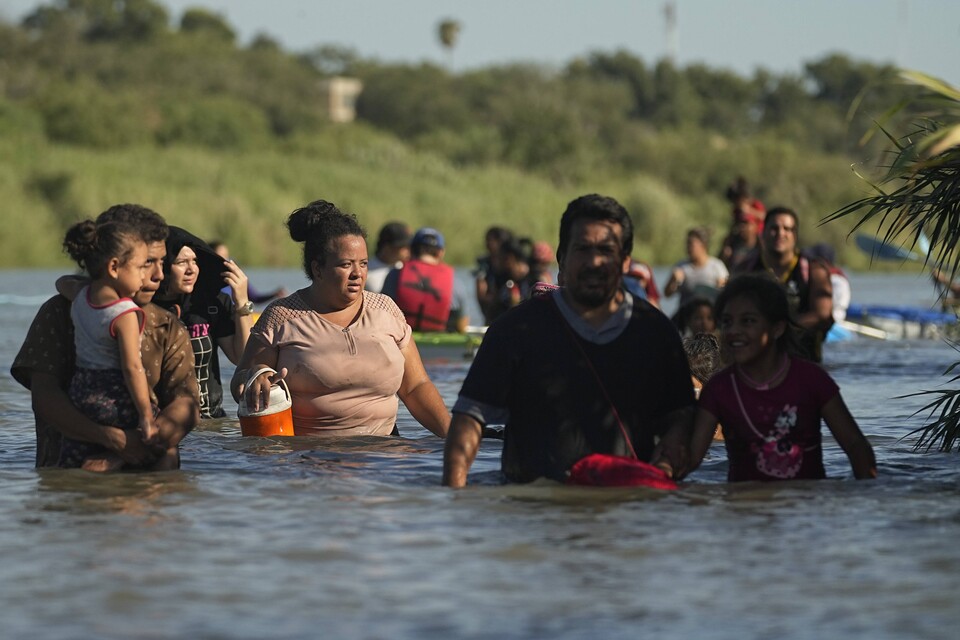 지난 1일(현지시간) 미국 텍사스주 이글 패스에서 멕시코에서 미국으로 건너온 이민자들이 리오 그란데 강 유역을 따라 설치된 콘체르티나 철조망 주변을 지나가고 있다. 현지 언론은 콘체르티나 철조망과 새로 설치된 부표가 부유식 장벽으로 사용되면서 리오그란데 강을 건너는 것이 더욱 어렵고 위험해지고 있다고 전했다. / 연합뉴스 
