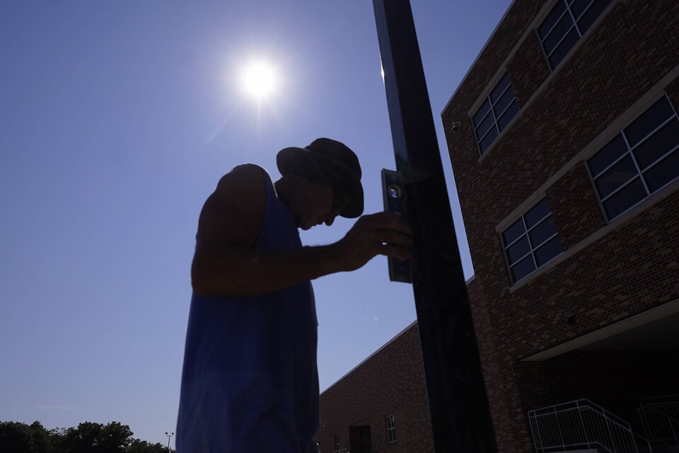 지난달 24일(현지시간) 미국 텍사스주 리처드슨에서 울타리 설치자 햇볕 아래에서 작업하고 있다. / 연합뉴스 