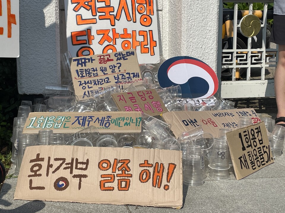 7일 서울환경연합이 정부서울청사 본관 앞에서 1회용컵 보증금제 전국 확대 시행을 촉구하는 피켓시위와 퍼포먼스를 진행했다./서울환경연합 제공