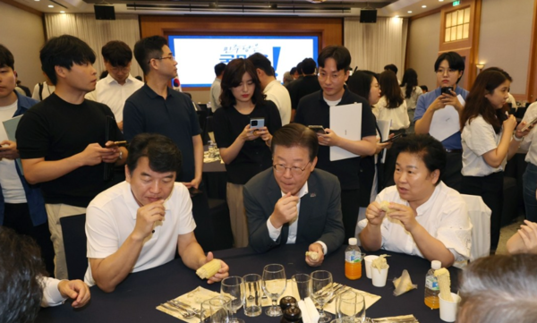 28일 강원도 원주 오크밸리에서 열린 더불어민주당 국회의원 워크숍에서 참석자들과 옥수수를 먹고 있는 이재명 대표./ 연합뉴스 