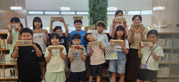 한전기술 열린도서관이 개설한 ‘캘리그라피’ 프로그램에 참여한 어린이들이 각자 꾸민 종이 필통을 선보이고 있다.(사진=한국전력기술)