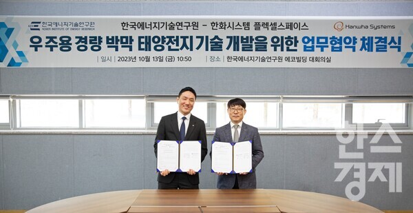 (왼쪽부터)안태훈 한화시스템 전문연구원 겸 플렉셀 스페이스 대표와 김현구 한국에너지기술연구원 재생에너지 연구소장이 '우주용 탠덤 태양전지' 기술 개발 및 경량 박막 태양전지 상용화 협력 MOU를 체결하고 기념촬영을 하고 있다. / 한화시스템 