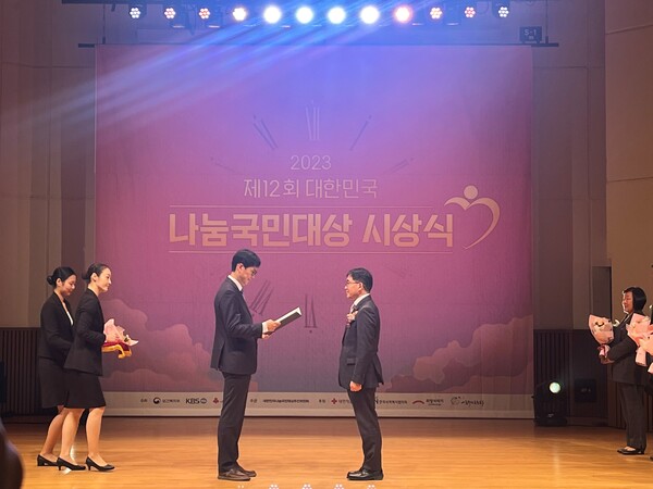 이재호 한국전력 노사협력처장이 김기남 보건복지부 인구정책실 사회서비스정책관에게 보건복지부장관상을 수상하고 있다. / 한전 제공.