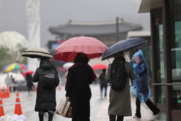 지난 14일 오후, 우산을 쓴 시민들이 비 내리는 서울 광화문광장을 지나가고 있다. / 연합뉴스.