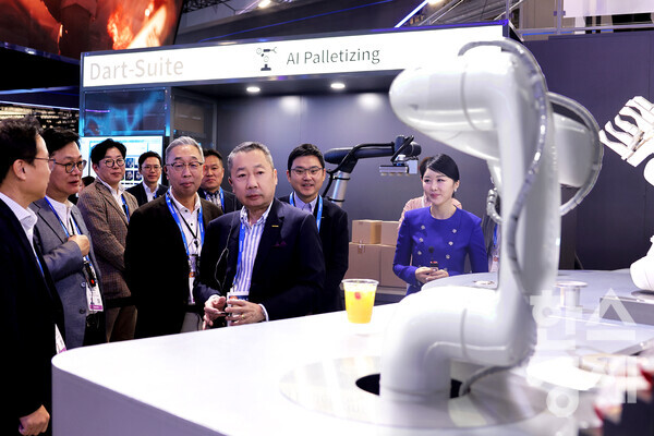 박정원 두산그룹 회장(가운데)과 박지원 그룹부회장(왼쪽)이 10일(현지시간) CES 2024에서 두산이 선보인 AI칵테일 로봇을 살펴보고 있다. / 두산그룹