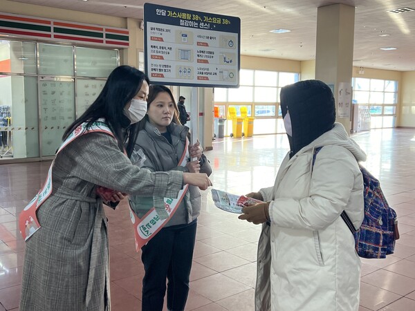 한국동서발전 직원이 시민에게 방한용품과 안내문을 나눠주고 에너지 절약 방법을 설명하고 있다. / 동서발전 제공. 