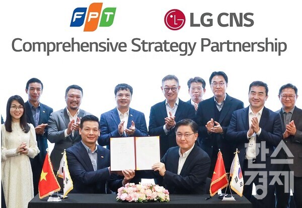  LG CNS 현신균 대표(오른쪽 다섯번째)와 FPT그룹 응우옌 반 코아(왼쪽 네번째) CEO 등이 지켜보는 가운데 통신/유통/서비스사업부장 박상균 전무와 FPT그룹 부 아잉 뚜 CTO가 MOU를 체결하고 기념촬영을 하고있다.