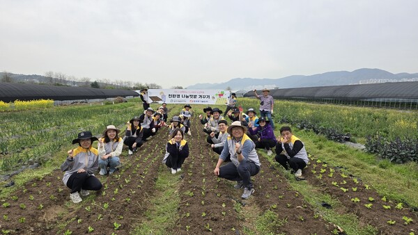한국동서발전 직원과 울산도시농업네트워크 회원 20명이 친환경 나눔 텃밭에서 함께 단체사진을 촬영하고 있다. / 동서발전 제공.