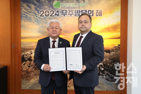 박인서 SK브로드밴드 케이블방송사업단 제작본부장(오른쪽)과 황인홍 무주군수가 업무협약식에서 기념촬영을 하고 있다. / SK브로드밴드