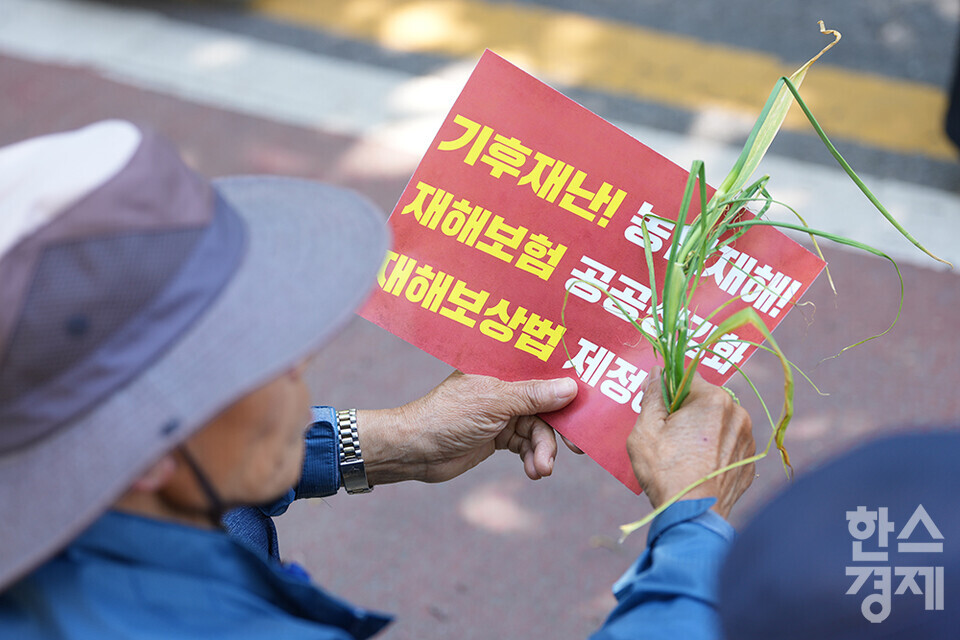 전국농민회총연맹 등 8개 농민단체가 모인 농민의길이 14일 오후 서울 여의도 국회 앞에서 기후재난시대 농민생존권대책촉구 결의대회를 열고 있다. 한 농민이 마늘과 손피켓을 들고 있다. /최대성 기자 dpdaesung@sporbiz.co.kr 2024.05.14.