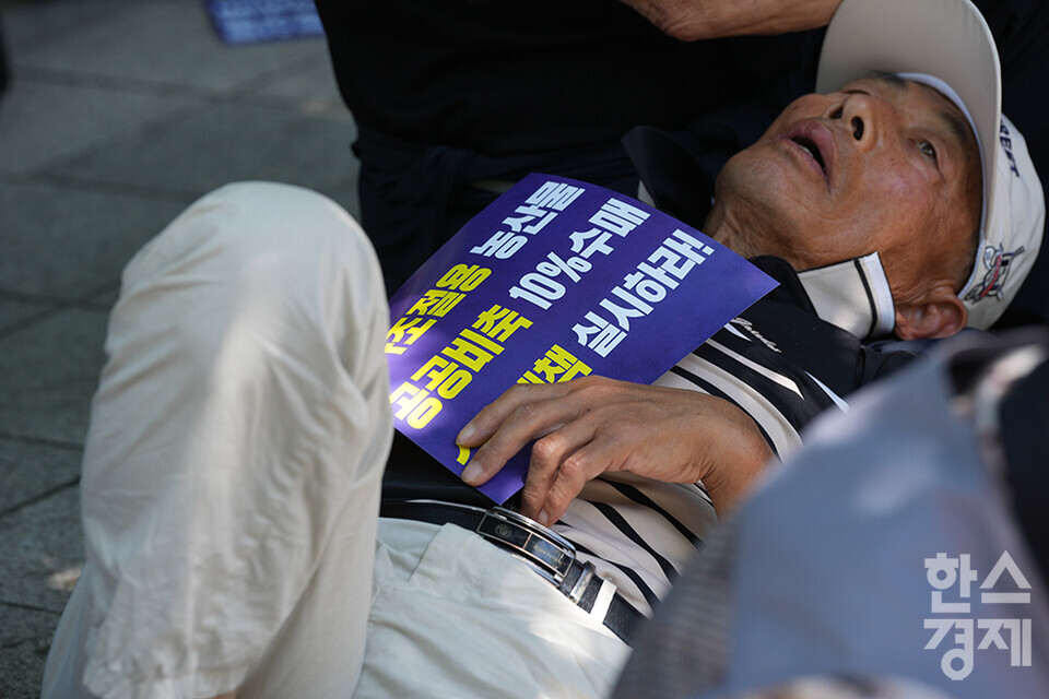 전국농민회총연맹 등 8개 농민단체가 모인 농민의길이 14일 오후 서울 여의도 국회 앞에서 기후재난시대 농민생존권대책촉구 결의대회를 열고 있다. 한 농민이 뜨거운 햇볕을 피해 손피켓을 안고 그늘에 누워 있다. /최대성 기자 dpdaesung@sporbiz.co.kr 2024.05.14.