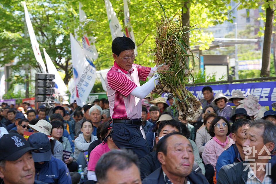 전국농민회총연맹 등 8개 농민단체가 모인 농민의길이 14일 오후 서울 여의도 국회 앞에서 기후재난시대 농민생존권대책촉구 결의대회를 열고 있다. 한 농민이 마늘을 연단으로 옮기고 있다. /최대성 기자 dpdaesung@sporbiz.co.kr 2024.05.14.