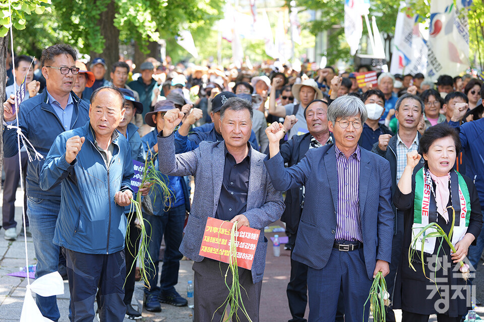 전국농민회총연맹 등 8개 농민단체가 모인 농민의길이 14일 오후 서울 여의도 국회 앞에서 기후재난시대 농민생존권대책촉구 결의대회를 열고 있다. 참석한 농민들이 마늘과 피켓을 들고 구호를 외치고 있다. /최대성 기자 dpdaesung@sporbiz.co.kr 2024.05.14.