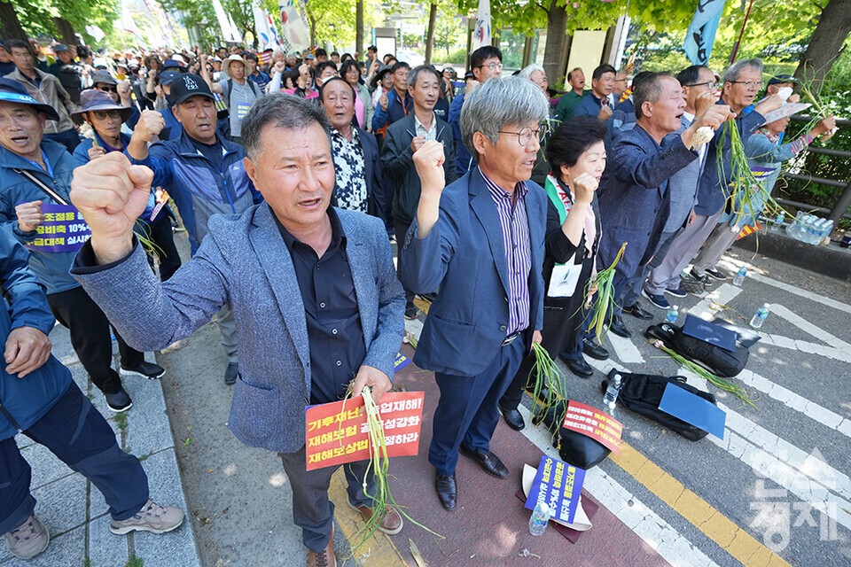 전국농민회총연맹 등 8개 농민단체가 모인 농민의길이 14일 오후 서울 여의도 국회 앞에서 기후재난시대 농민생존권대책촉구 결의대회를 열고 있다. 참석한 농민들이 마늘과 피켓을 들고 구호를 외치고 있다. /최대성 기자 dpdaesung@sporbiz.co.kr 2024.05.14.