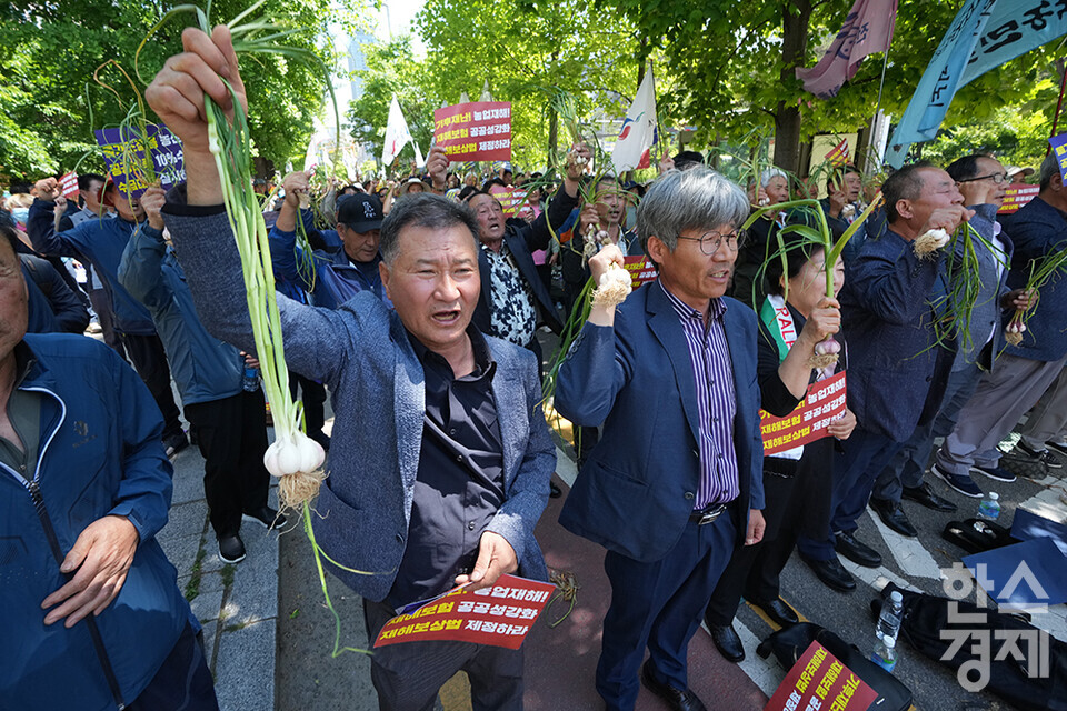 전국농민회총연맹 등 8개 농민단체가 모인 농민의길이 14일 오후 서울 여의도 국회 앞에서 기후재난시대 농민생존권대책촉구 결의대회를 열고 있다. 참석한 농민들이 마늘과 피켓을 들고 구호를 외치고 있다. /최대성 기자 dpdaesung@sporbiz.co.kr 2024.05.14.