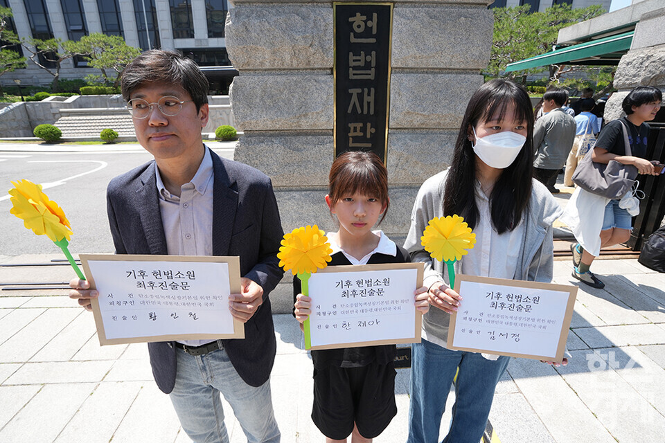 시민기후소송 청구인인 황인철 씨(왼쪽부터), 청소년기후소송 청구인 김서경 씨, 아기기후소송 청구인 한제아 양이 21일 오후 서울 종로구 헌법재판소 정문 앞에서 열린 ‘희망'의 메리골드가 피어난 기후소송 2차 공개변론 기자회견서 최후진술문을 들고 있다. /최대성 기자 dpdaesung@sporbiz.co.kr 2024.05.21