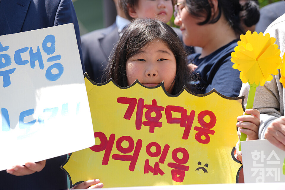 21일 오후 서울 종로구 헌법재판소 정문 앞에서 ‘희망'의 메리골드가 피어난 기후소송 2차 공개변론 기자회견이 열리고 있다. 참석자들이 손 피켓을 들고 있다. /최대성 기자 dpdaesung@sporbiz.co.kr 2024.05.21
