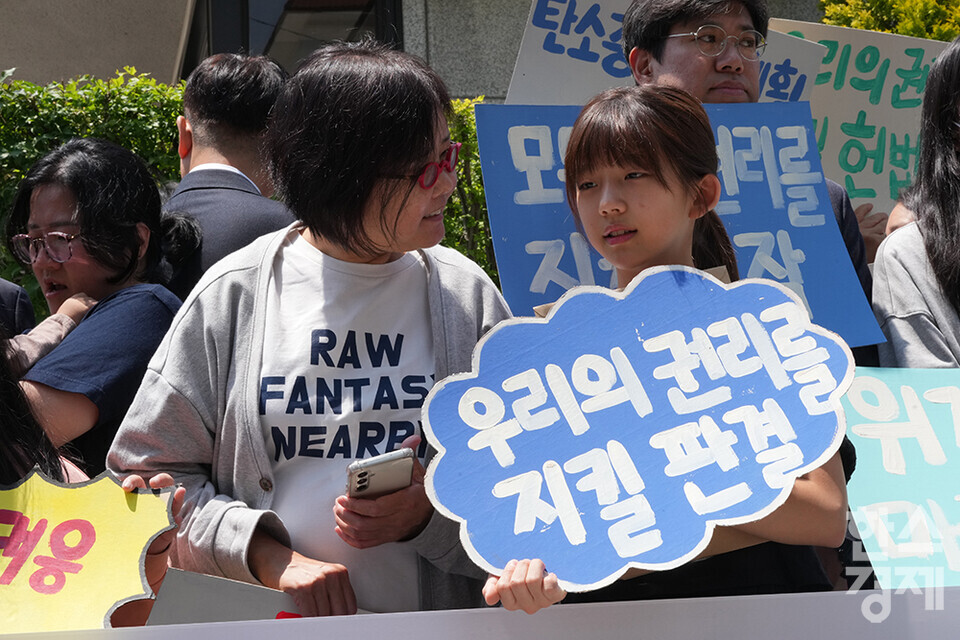 21일 오후 서울 종로구 헌법재판소 정문 앞에서 ‘희망'의 메리골드가 피어난 기후소송 2차 공개변론 기자회견이 열리고 있다. 참석자들이 손 피켓을 들고 있다. /최대성 기자 dpdaesung@sporbiz.co.kr 2024.05.21