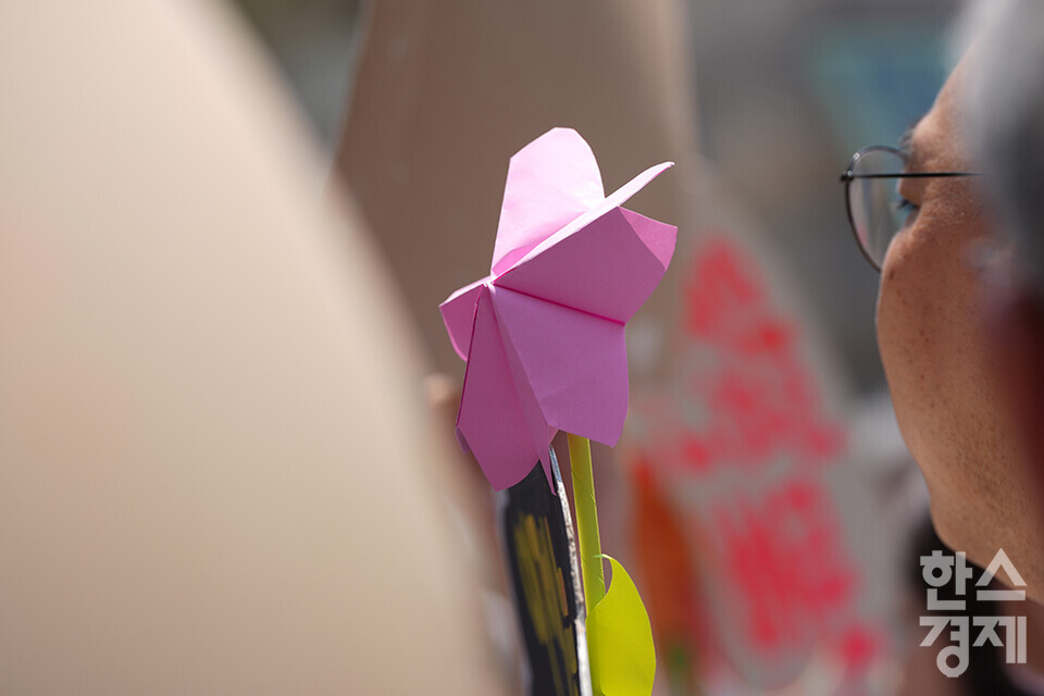 21일 오후 서울 종로구 헌법재판소 정문 앞에서 ‘희망'의 메리골드가 피어난 기후소송 2차 공개변론 기자회견이 열리고 있다. 참석자들이 종이꽃을 들고 있다. /최대성 기자 dpdaesung@sporbiz.co.kr 2024.05.21