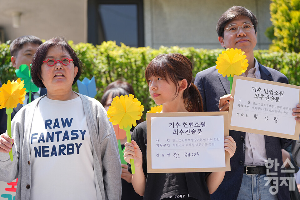 21일 오후 서울 종로구 헌법재판소 정문 앞에서 ‘희망'의 메리골드가 피어난 기후소송 2차 공개변론 기자회견이 열리고 있다. 참석자들이 손 피켓을 들고 있다. /최대성 기자 dpdaesung@sporbiz.co.kr 2024.05.21