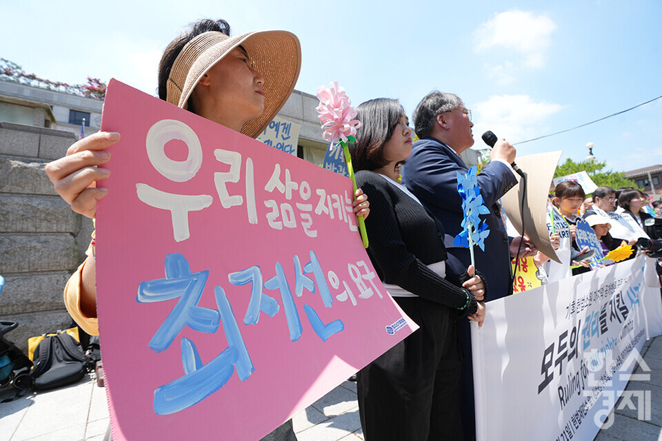 21일 오후 서울 종로구 헌법재판소 정문 앞에서 ‘희망'의 메리골드가 피어난 기후소송 2차 공개변론 기자회견이 열리고 있다. 참석자들이 손 피켓을 들고 있다. /최대성 기자 dpdaesung@sporbiz.co.kr 2024.05.21